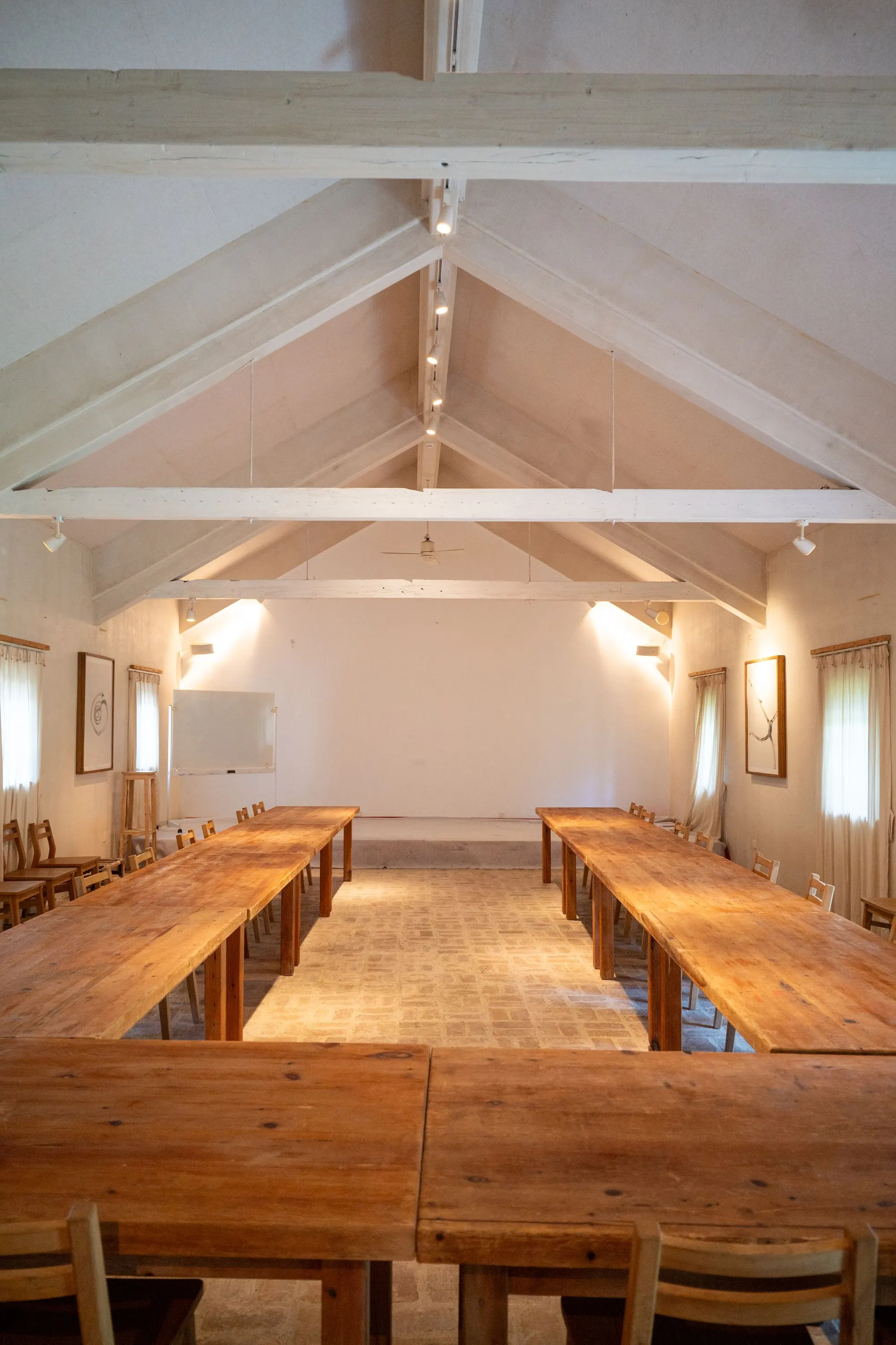 Long wooden tables in a timber hall, set for an offsite
