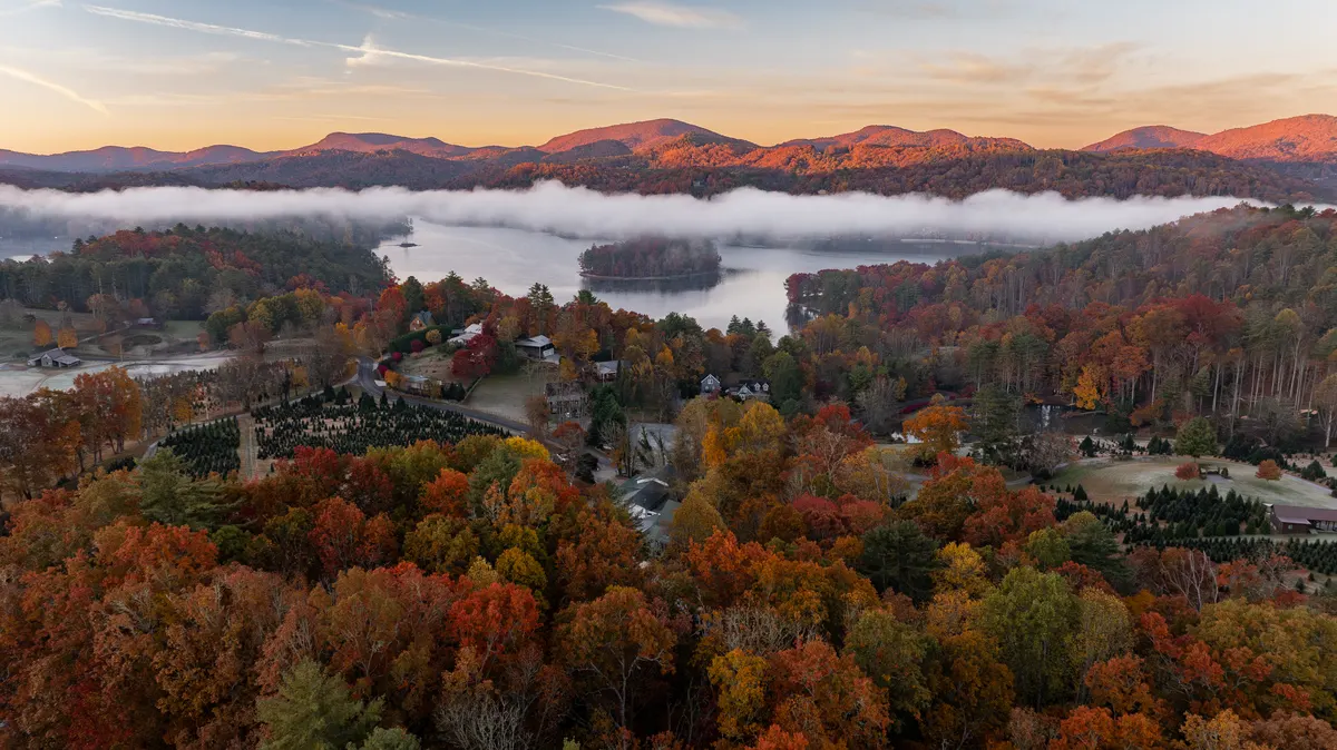 Fog lying over Lake Glenville at sunrise, mountains lit orange